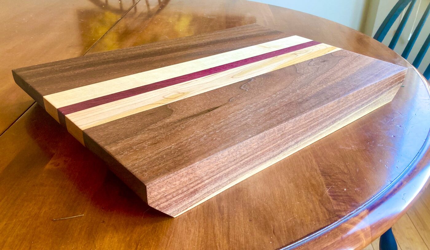 A handcrafted cutting board in walnut, maple, and purpleheart